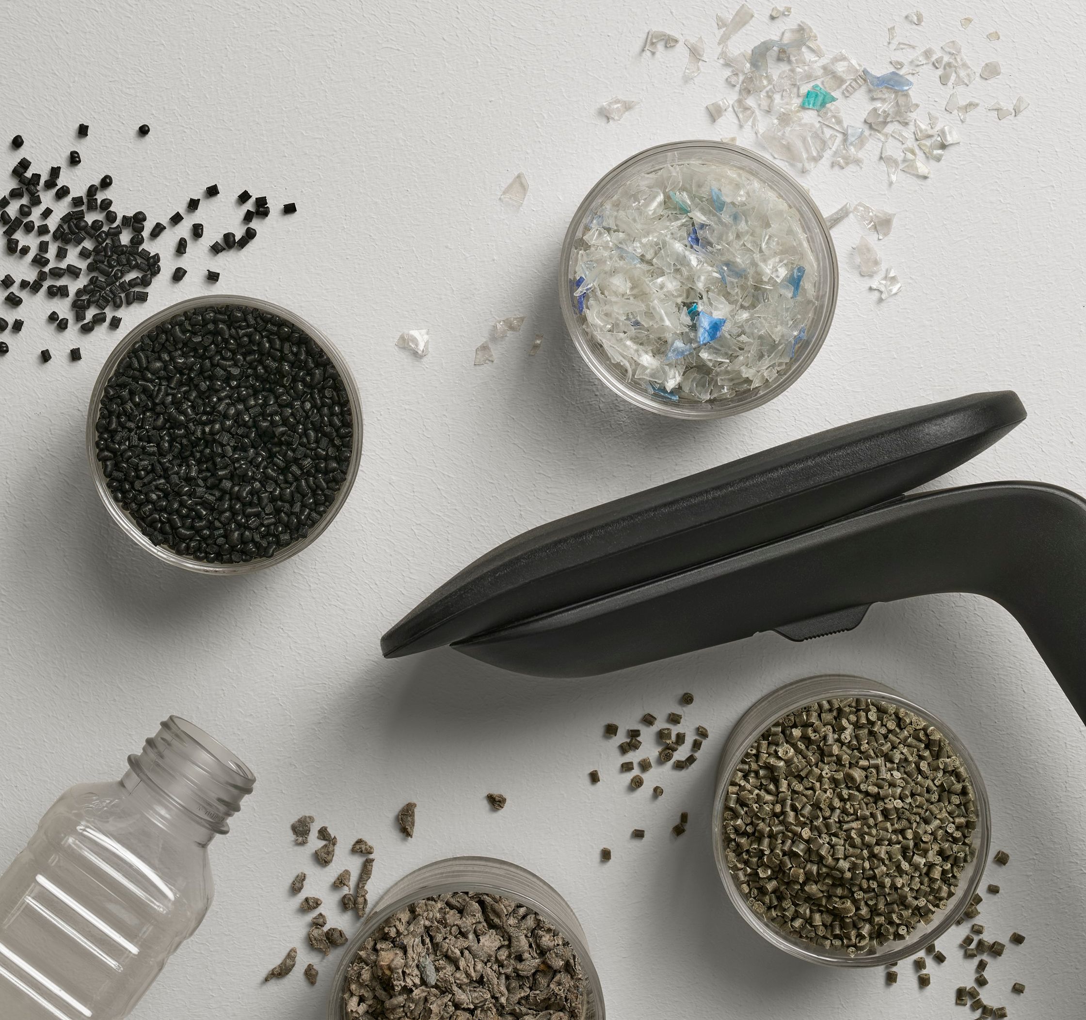 Područka židle Steelcase mezi miskami s recyklovaným plastem, granulemi a PET lahví