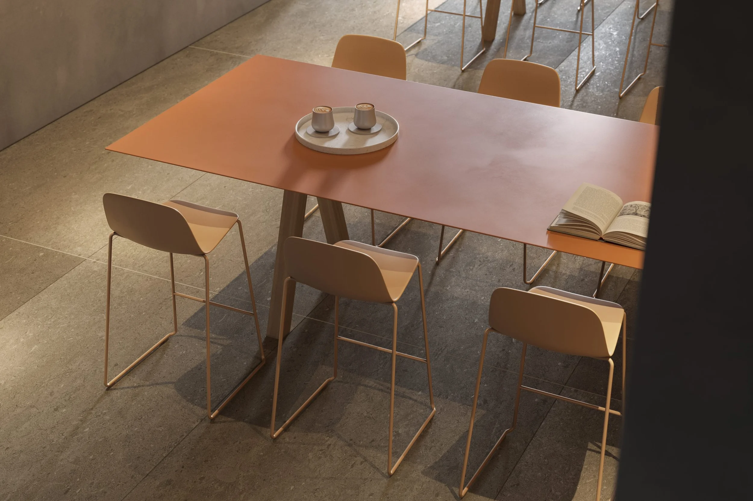 Stůl Trestle od Viccarbe s terakotovou deskou a barovými židlemi v téže barvě na kamenné podlaze